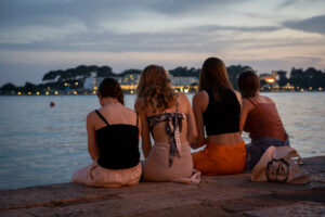 Meisjes aan de oever bij valavond in Poreč in Kroatië